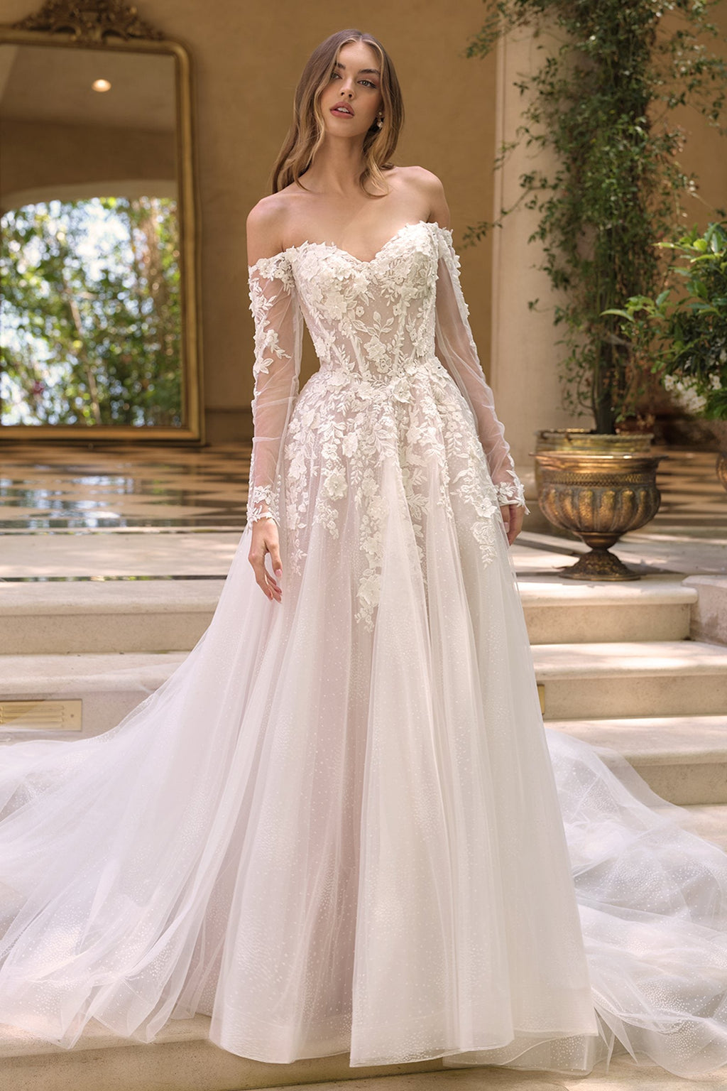 Andrea & Leo WL067 is a women’s wedding dress for wedding, formal events. Source details list a Ball gown silhouette. Design details include Off-the-shoulder sweetheart neckline with sheer illusion sleeves & 3D floral lace appliqué. Fabric/material details: Glittered tulle skirt layered beneath lace-appliqued bodice. Fit detail: Structured corset-style bodice with boning for shape and support. Colors listed: off white/nude. Use the product options for exact color and size selection.