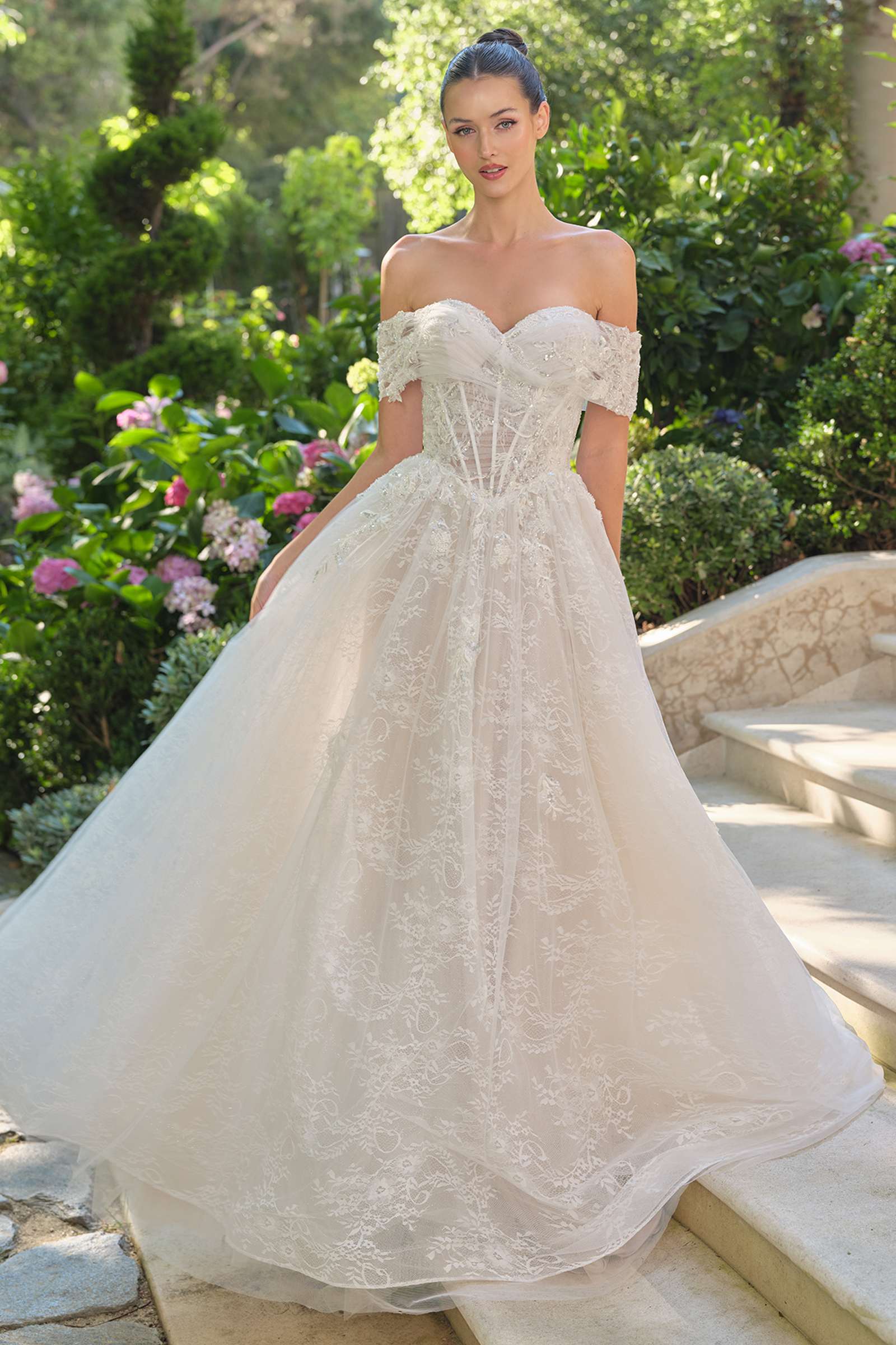 Andrea & Leo WL090 is a women’s wedding dress for wedding, formal events. Source details list a Ball gown silhouette. Design details include Off-the-shoulder ruched neckline, sheer corset bodice, and 3D floral appliqué. Fabric/material details: Embroidered lace tulle over layers of soft mesh. Fit detail: Exposed boning corset for support and shape; full gathered skirt for volume. Colors listed: off white/nude. Use the product options for exact color and size selection.